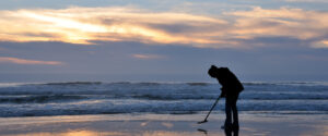 metal detect on beach at dusk