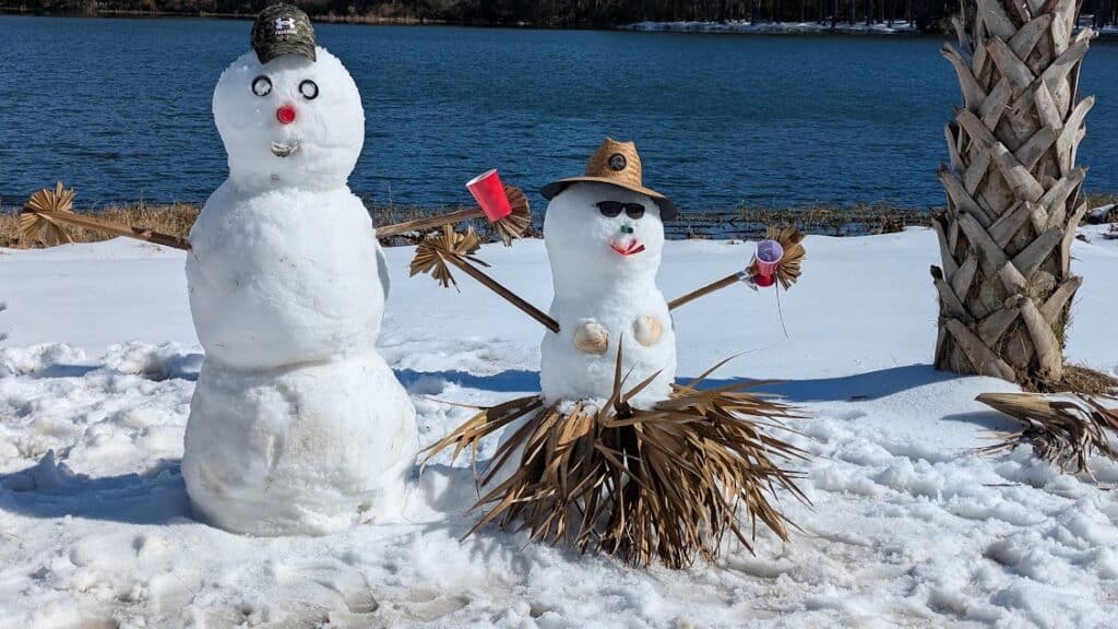 Snowmen next to a palm tree after rare Florida snowfall